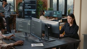 two-focused-coders-facing-each-other-writing-code-in-software-development-office-e1696735601562.jpg